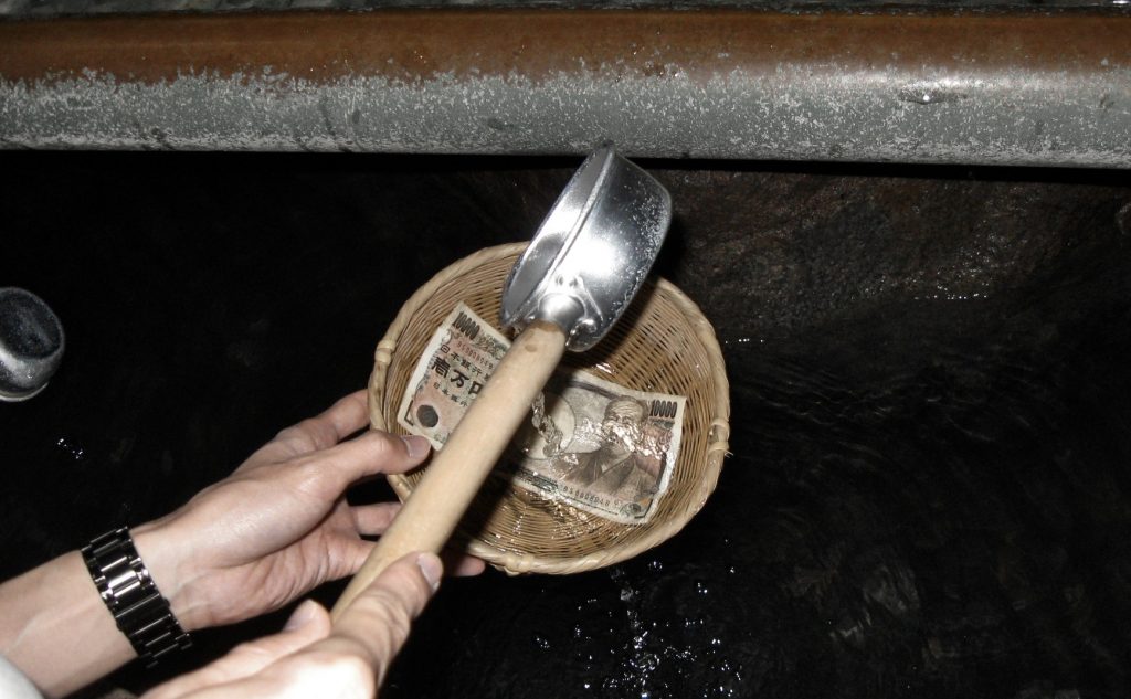 Money washing at Zeniarai Benten Shrine in Kamakura. Credit: Vigyani. Licensed under CC.