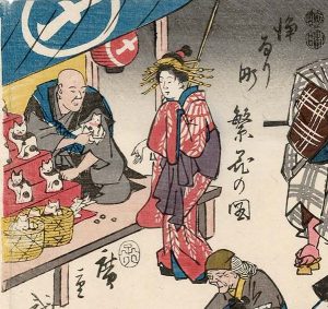 Drawing of a stall selling Maneki-neko figures in 1852. "Joruri-machi Hanka no zu" by Utagawa Hiroshige, 1852. Public Domain.